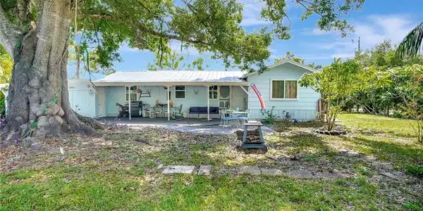 Image 2: Front view of property featuring a patio, metal roof, and a yard