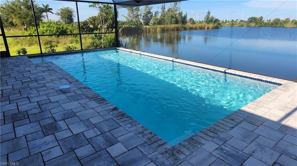 Image 4: Swimming pool featuring a water view, a lanai, and a patio area