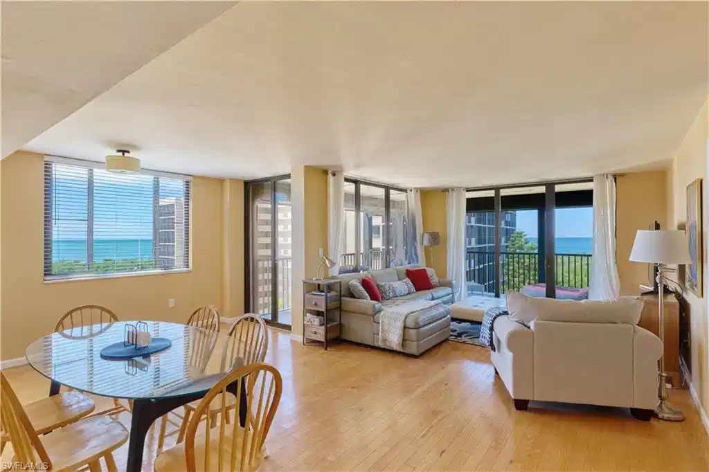 Image 1: Living area with light wood-style flooring and floor to ceiling windows