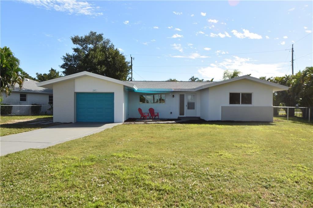 Image 1: Ranch-style home with a garage, driveway, and stucco siding