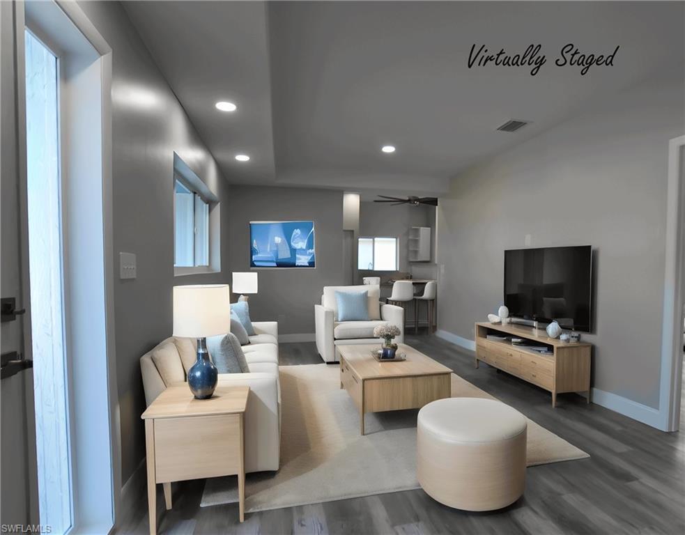Image 2: Living room with LVP floors, a ceiling fan, and recessed lighting