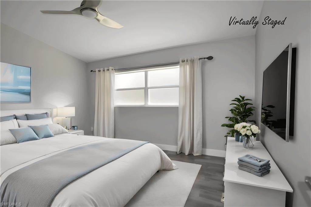 Image 4: Bedroom with lofted ceiling, LVP floors, and a ceiling fan