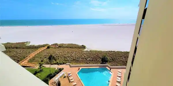 Image 3: Community pool featuring view of water and beach and a patio area