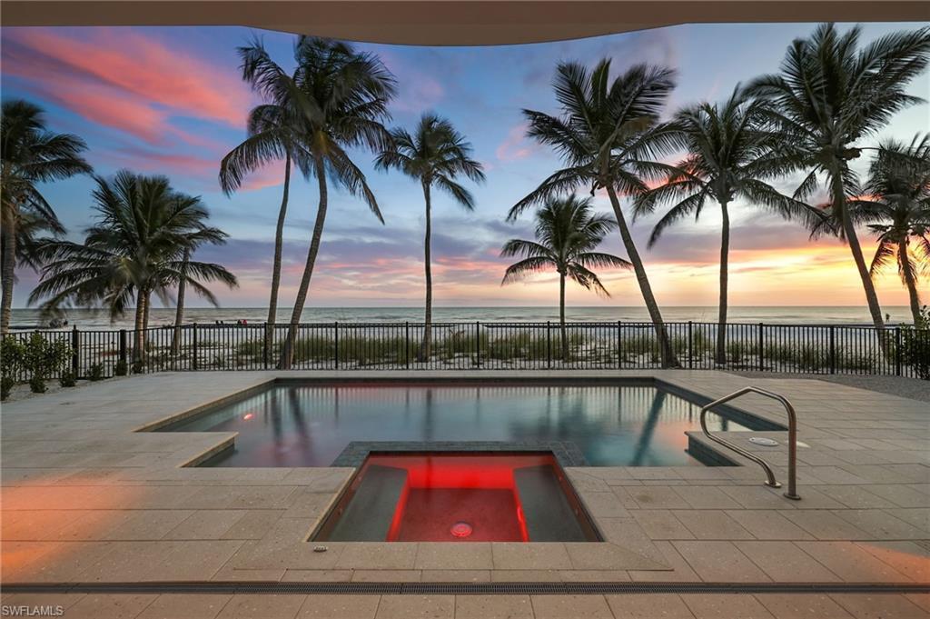 Image 4: Gulf-Front Luxury with Poolside Glow &ndash; This stunning beachfront residence showcases multiple balconies, walls of glass, and a sparkling resort-style pool illuminated against the evening sky. Framed by swaying palms and steps from the sand, it&rsquo;s the ultimate setting for coastal living and entertaining.- Photo Virtually Edited