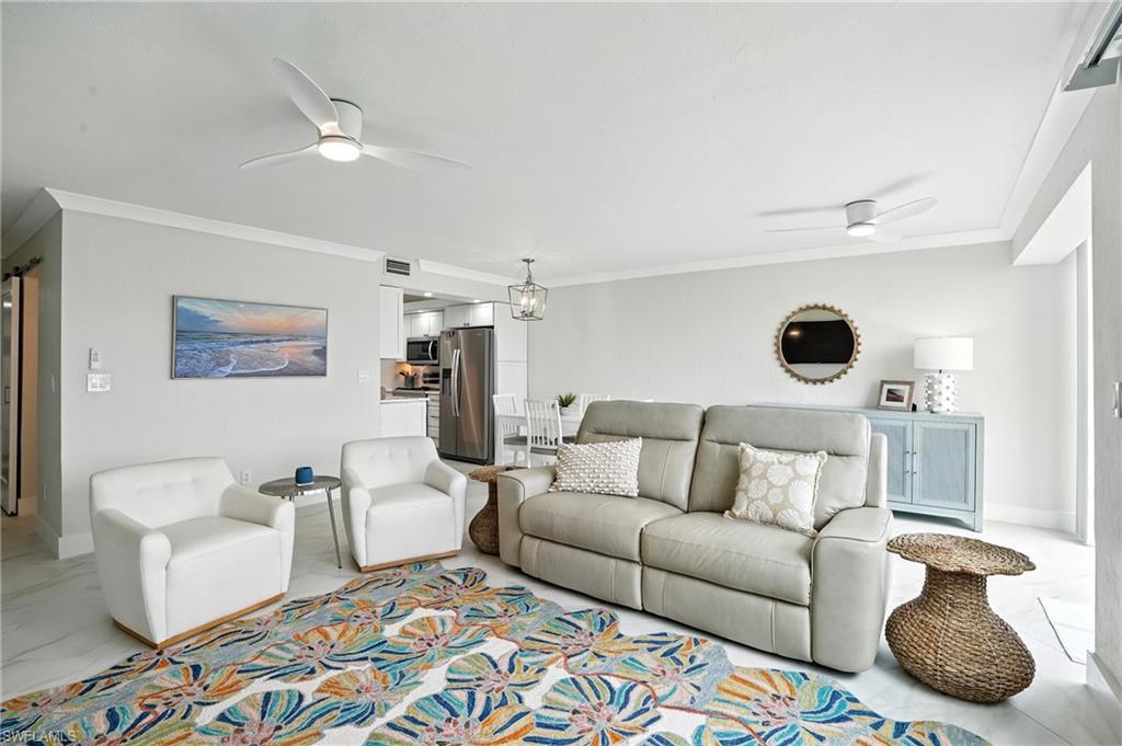 Image 3: Living room featuring ceiling fan, ornamental molding, and marble look tile flooring