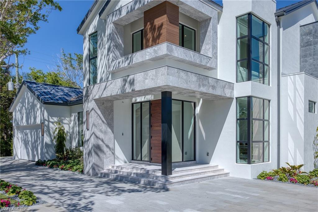 Image 2: Property entrance with stucco siding and a garage