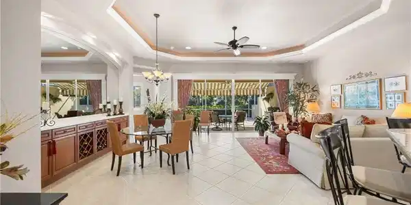 Image 2: Dining area featuring a tray ceiling, light tile patterned floors, recessed lighting, a ceiling fan, and a chandelier