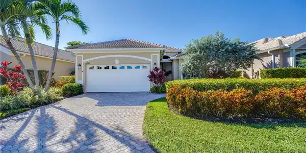 Image 4: View of front of home featuring stucco siding, decorative driveway, a front lawn, a garage, and a tile roof