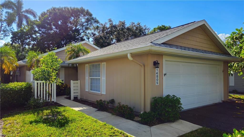 Image 2: View of side of property featuring a shingled roof and an attached garage