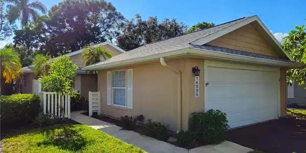 Image 2: View of side of property featuring a shingled roof and an attached garage