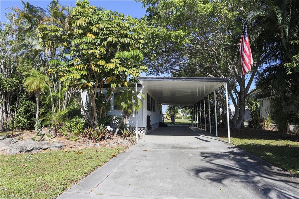 Image 2: View of vehicle parking featuring driveway and a carport