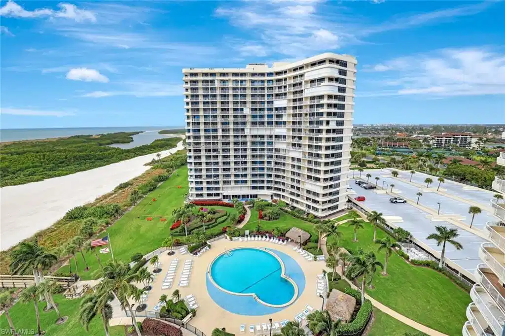 Image 1: Bird's eye view of apartment complex and a nearby body of water