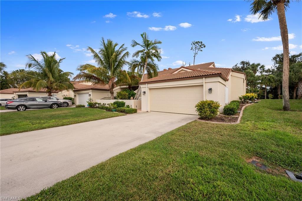 Image 2: Mediterranean / spanish home with a tile roof, stucco siding, concrete driveway, a front lawn, and an attached garage