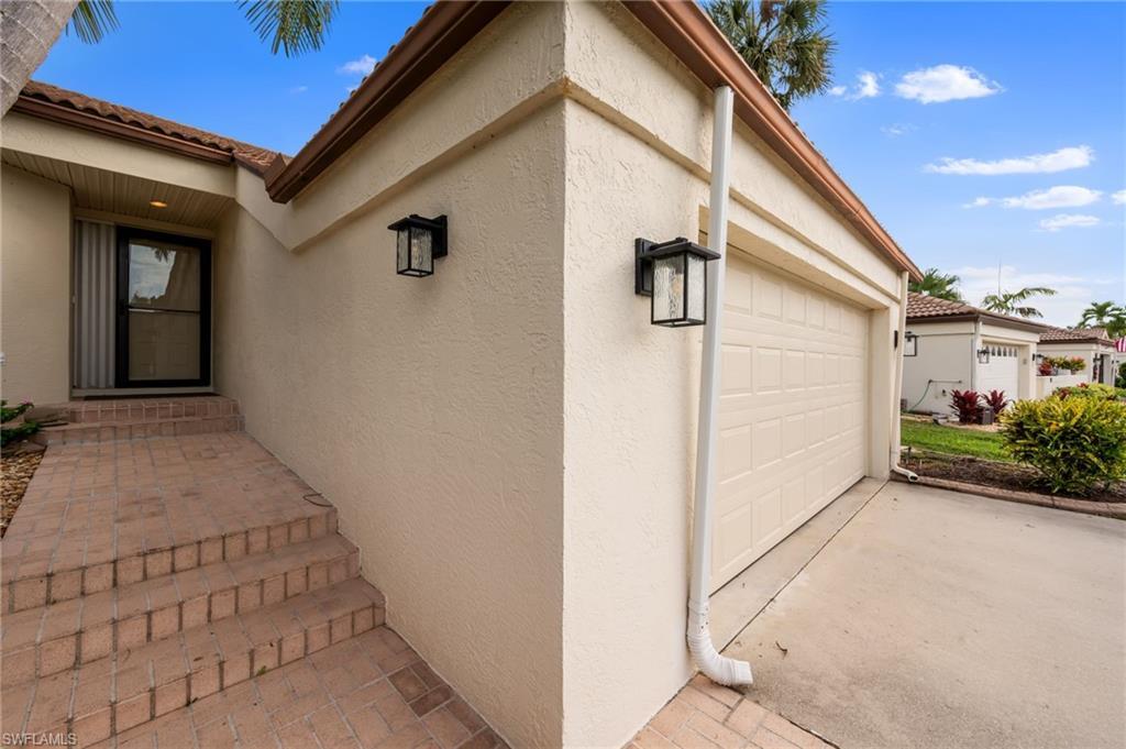 Image 3: Entrance to property featuring a garage, stucco siding, and concrete driveway