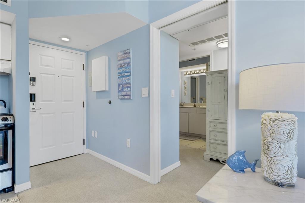 Image 3: Entrance foyer featuring light carpet and baseboards