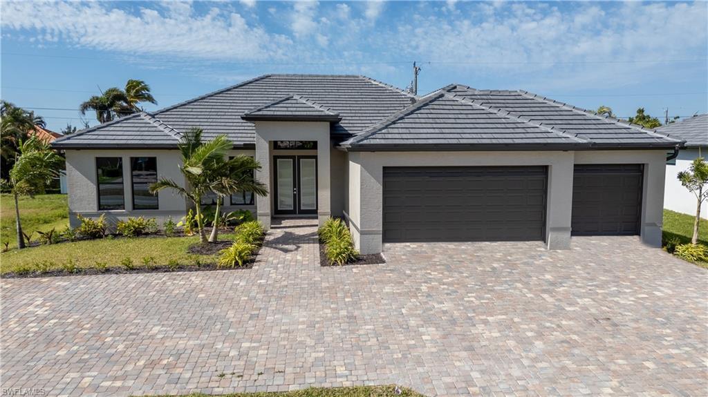 Image 1: Ranch-style house with french doors, an attached garage, driveway, and stucco siding