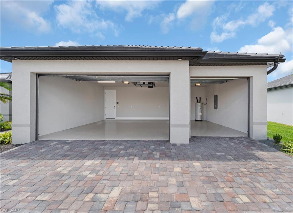 Image 3: Garage featuring driveway and electric water heater