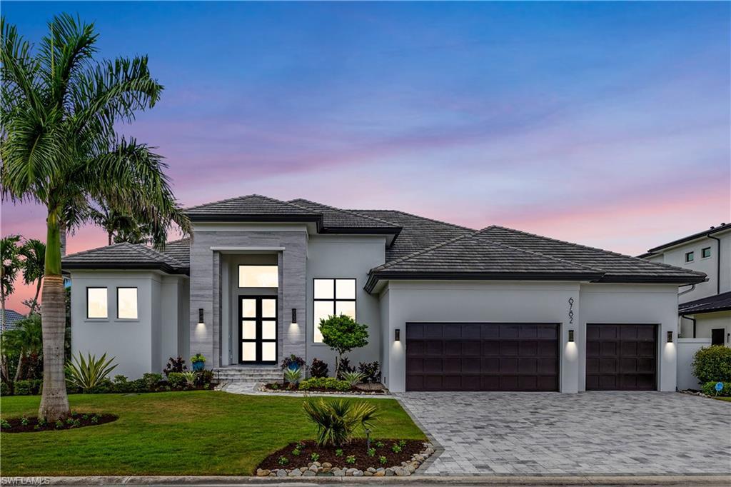 Image 2: Stunning facade with contemporary lighting, pavered driveway, fresh landscaping!