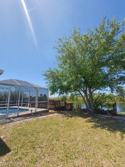 Image 2: View of yard with glass enclosure, a sunroom, and a patio area