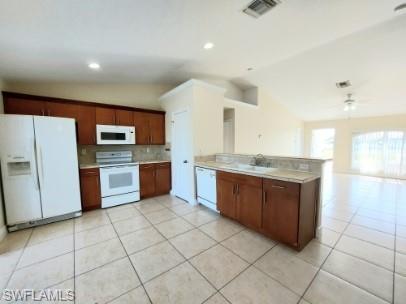 Image 4: Kitchen featuring vaulted ceiling, white appliances, decorative backsplash, light countertops, and a peninsula