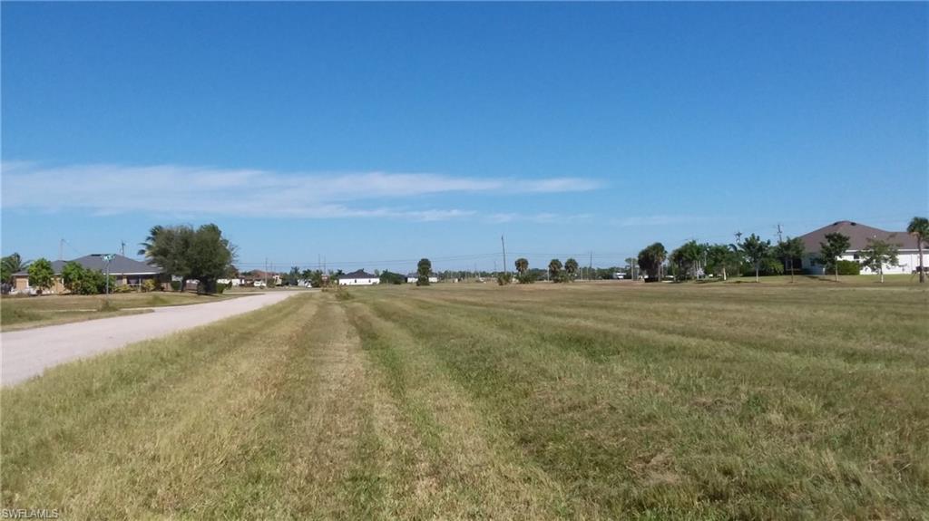 Image 1: View of asphalt road featuring a rural view