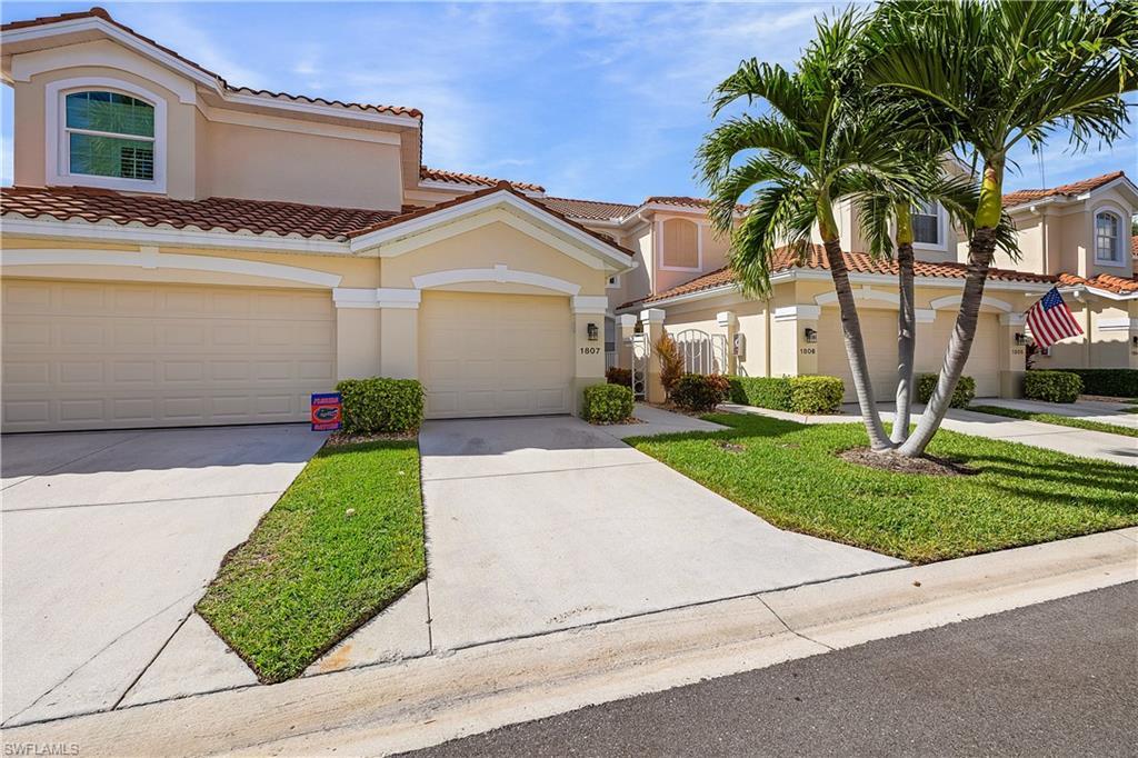 Image 2: Mediterranean / spanish-style home featuring a tiled roof, concrete driveway, stucco siding, a front lawn, and an attached garage