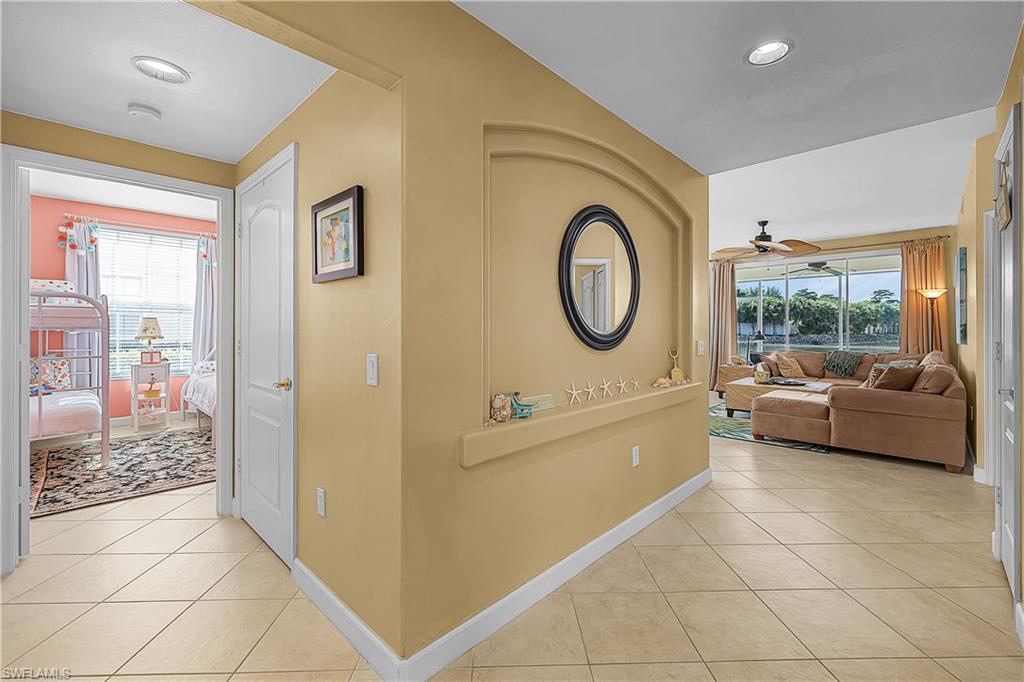 Image 3: Hallway with light tile patterned floors and recessed lighting