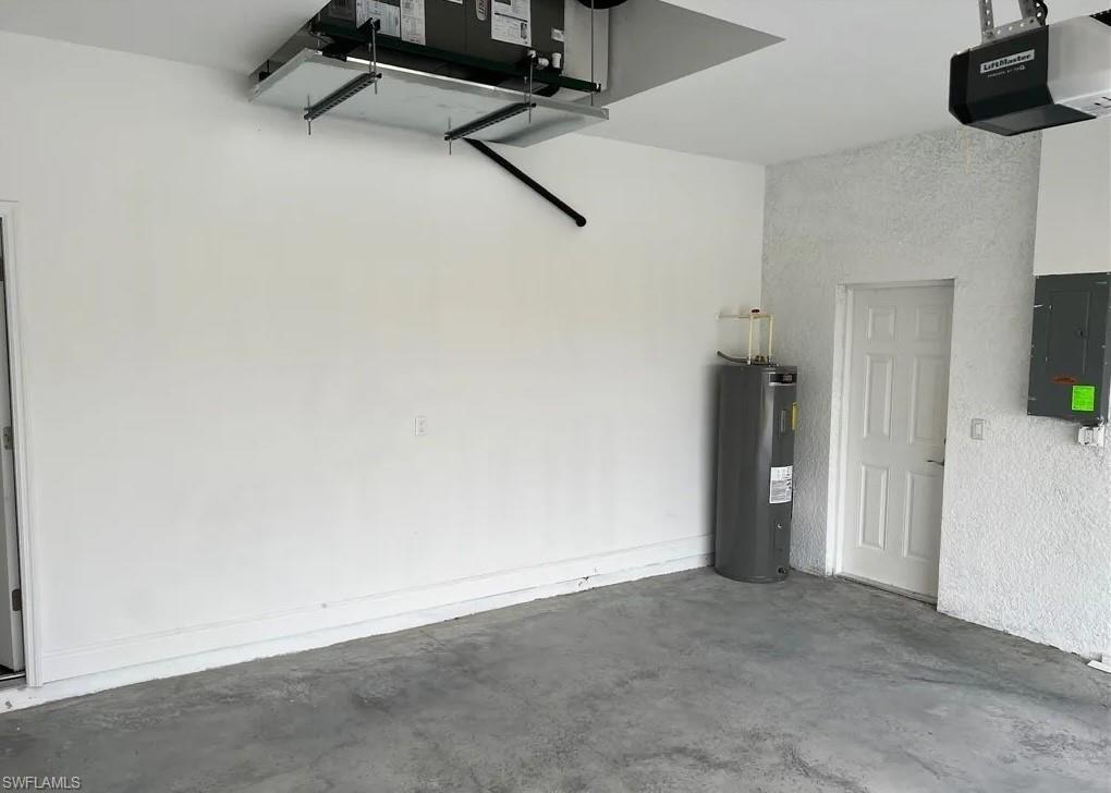 Image 4: Garage featuring a garage door opener, electric panel, and water heater