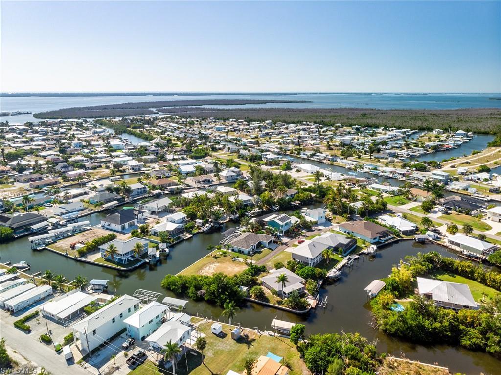 Image 4: Aerial view of property and surrounding area with a nearby body of water and nearby suburban area