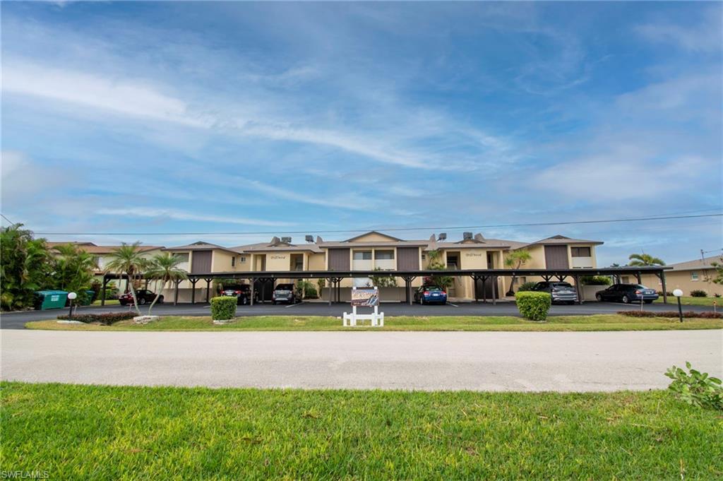 Image 3: View of front of house featuring covered parking and a front lawn