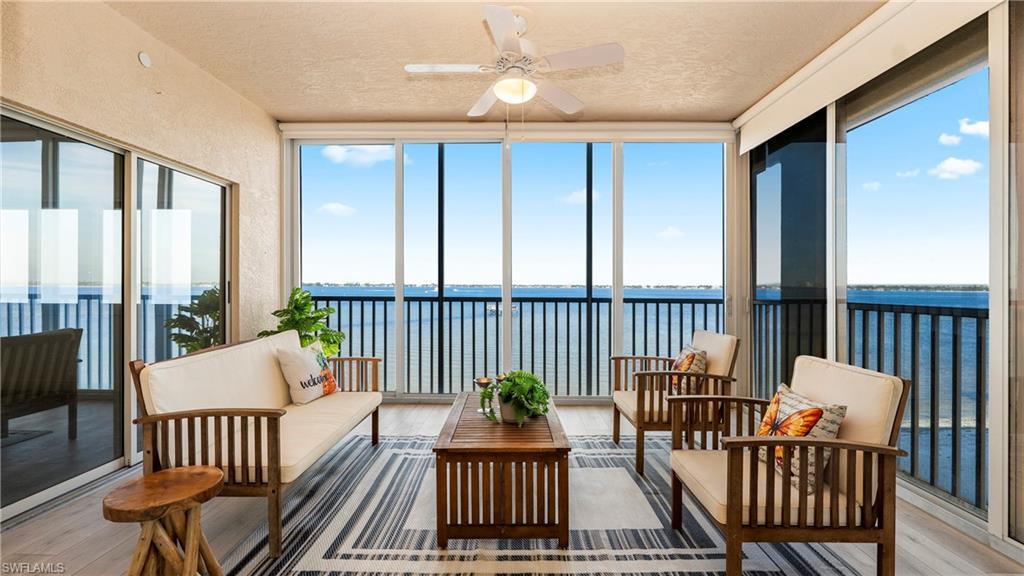 Image 1: Sunroom featuring a water view, hardwood / wood-style floors, a textured ceiling, and expansive windows