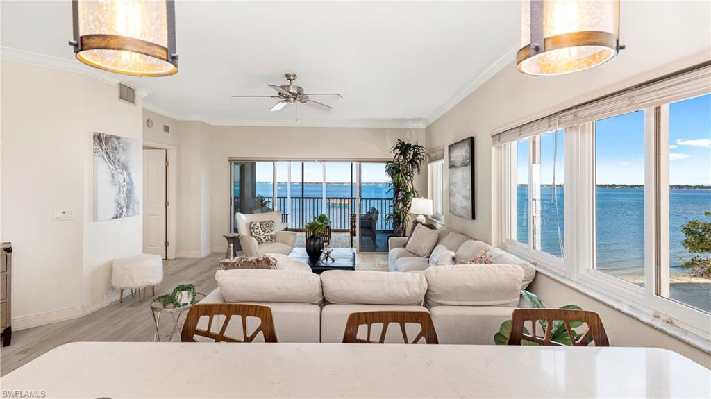 Image 4: Living area featuring a water view, wood finished floors, crown molding, and a ceiling fan