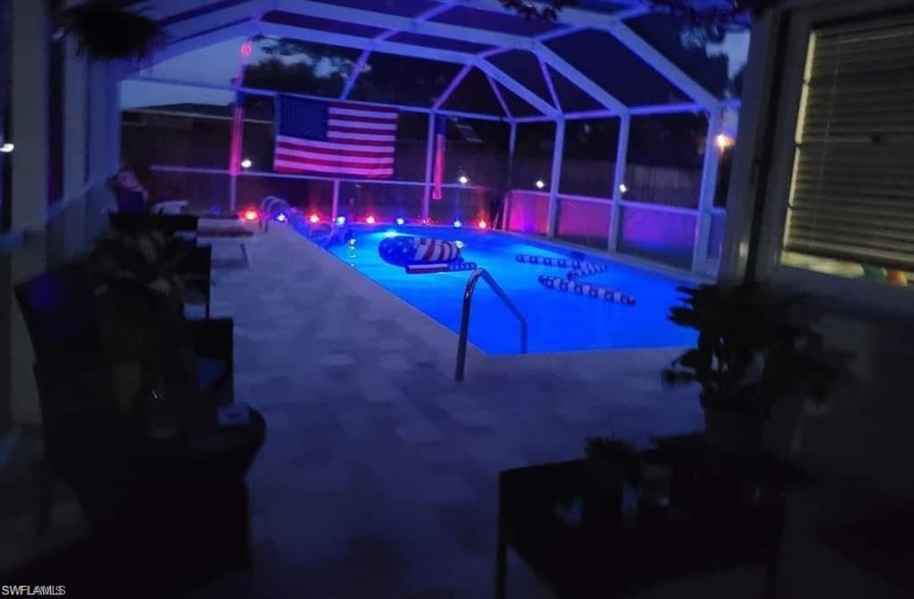 Image 2: View of pool with a patio area and a lanai