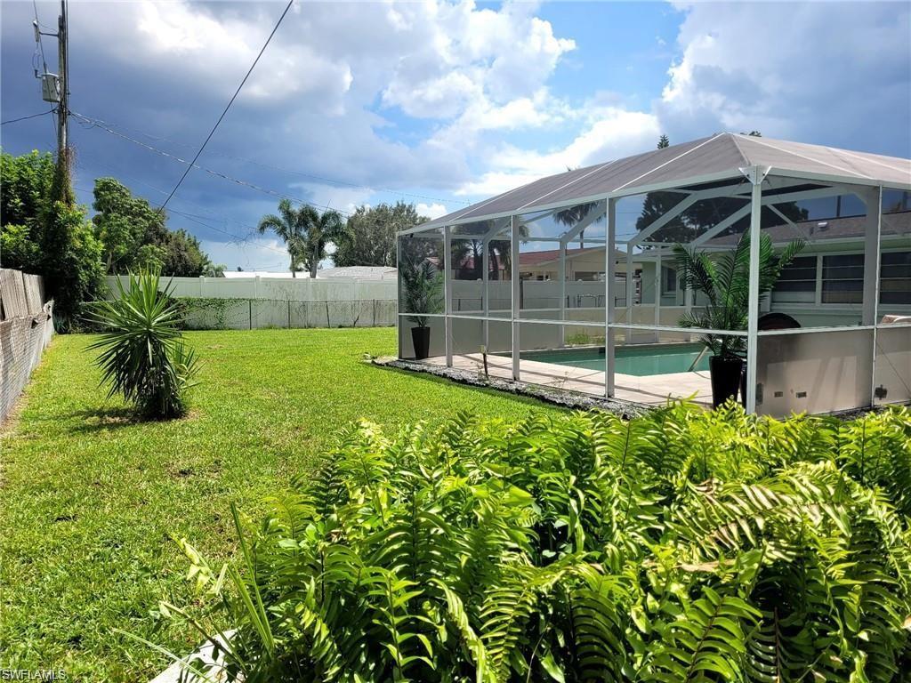 Image 4: View of yard featuring glass enclosure and a fenced in pool
