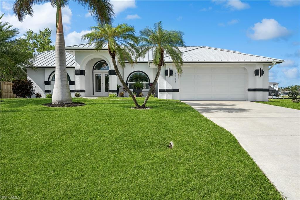 Image 1: Entrance to property with a lawn and french doors