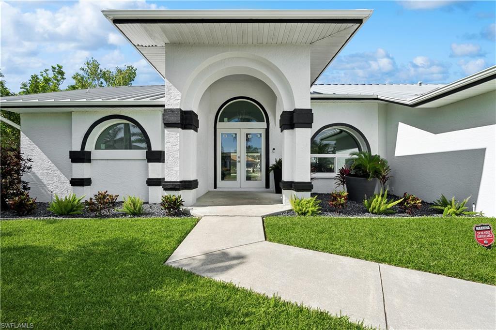 Image 2: View of front of house with french doors, a garage, and a front lawn