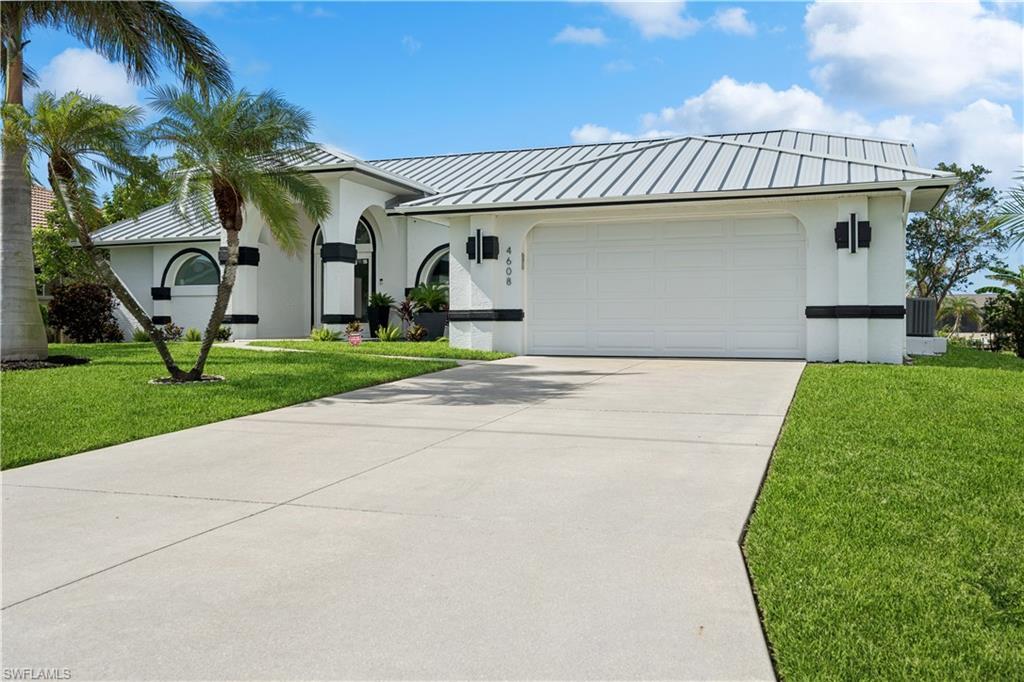 Image 3: View of front facade featuring cooling unit, a front yard, and a garage