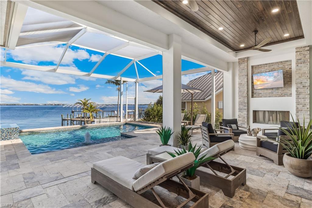 Image 1: View of patio / terrace with outdoor lounge area, ceiling fan, a water view, and glass enclosure