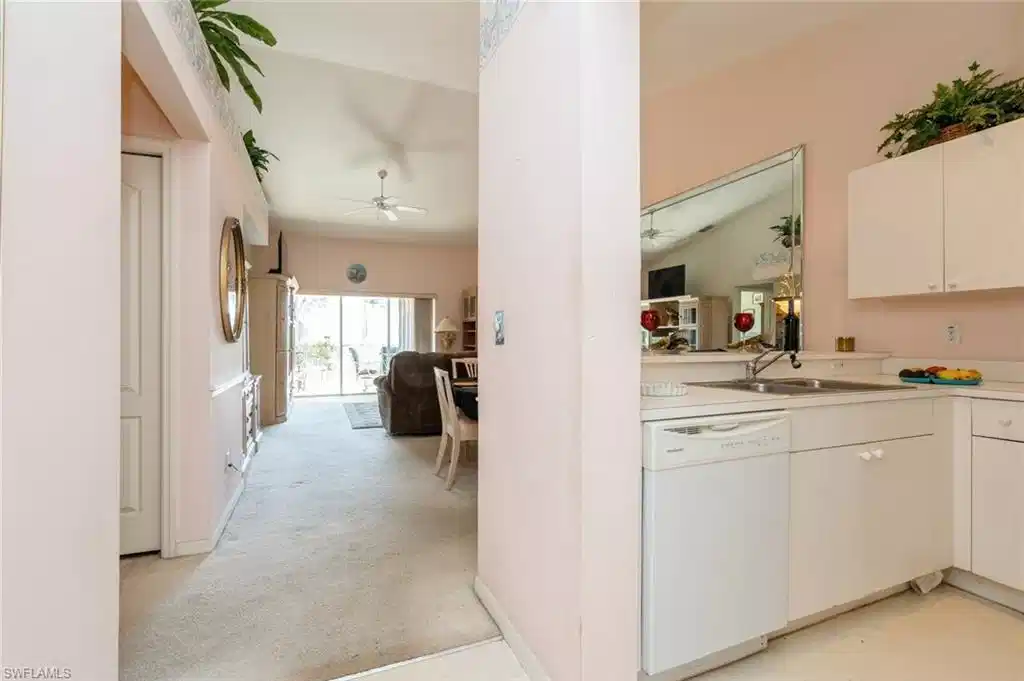 Image 1: Kitchen with white cabinetry, dishwasher, ceiling fan, sink, and light carpet
