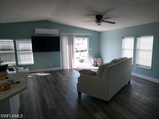 Image 2: Living room featuring lofted ceiling, ceiling fan, a wall mounted AC, and dark hardwood / wood-style floors
