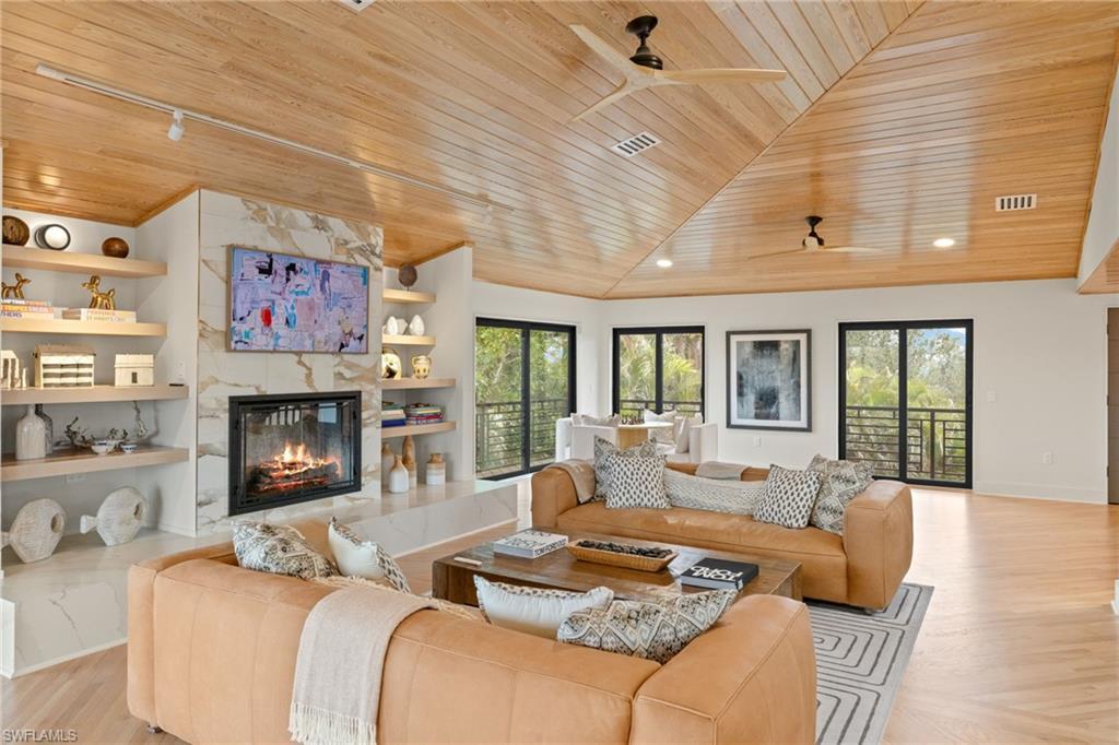 Image 4: Living room featuring a healthy amount of sunlight, a high end fireplace, built in features, and wooden ceiling