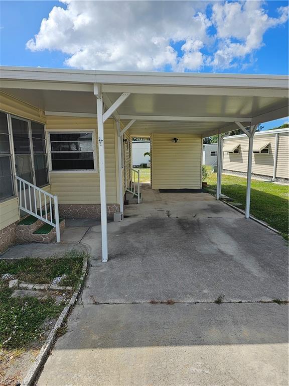 Image 2: View of parking / parking lot with an attached carport, driveway, and entry steps