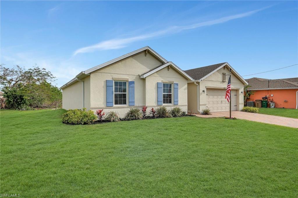 Image 2: Single story home with driveway, a front yard, an attached garage, and stucco siding