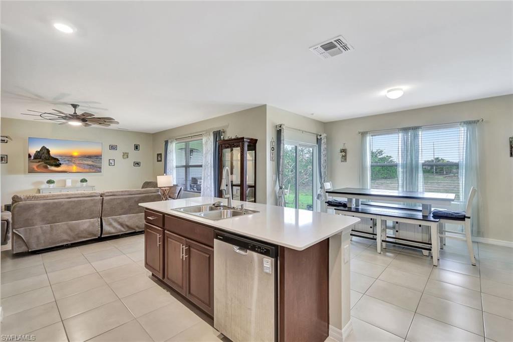 Image 3: Kitchen featuring visible vents, a sink, open floor plan, stainless steel dishwasher, and light tile patterned floors
