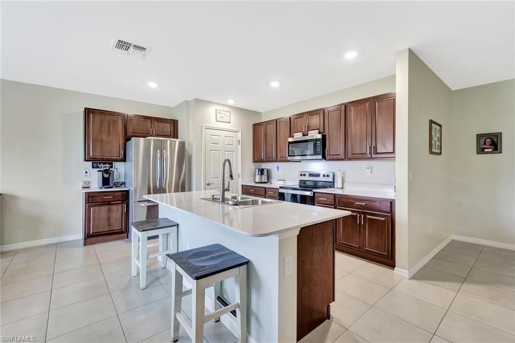 Image 4: Kitchen featuring a sink, visible vents, light tile patterned floors, and appliances with stainless steel finishes