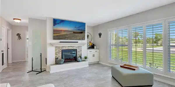 Image 3: Living room featuring plenty of natural light, baseboards, and a glass covered fireplace