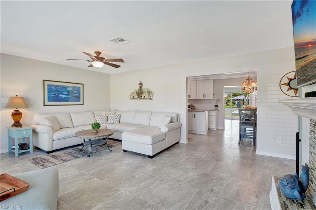 Image 4: Living room featuring ceiling fan with notable chandelier, baseboards, and visible vents