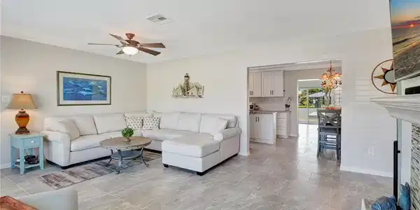 Image 4: Living room featuring ceiling fan with notable chandelier, baseboards, and visible vents