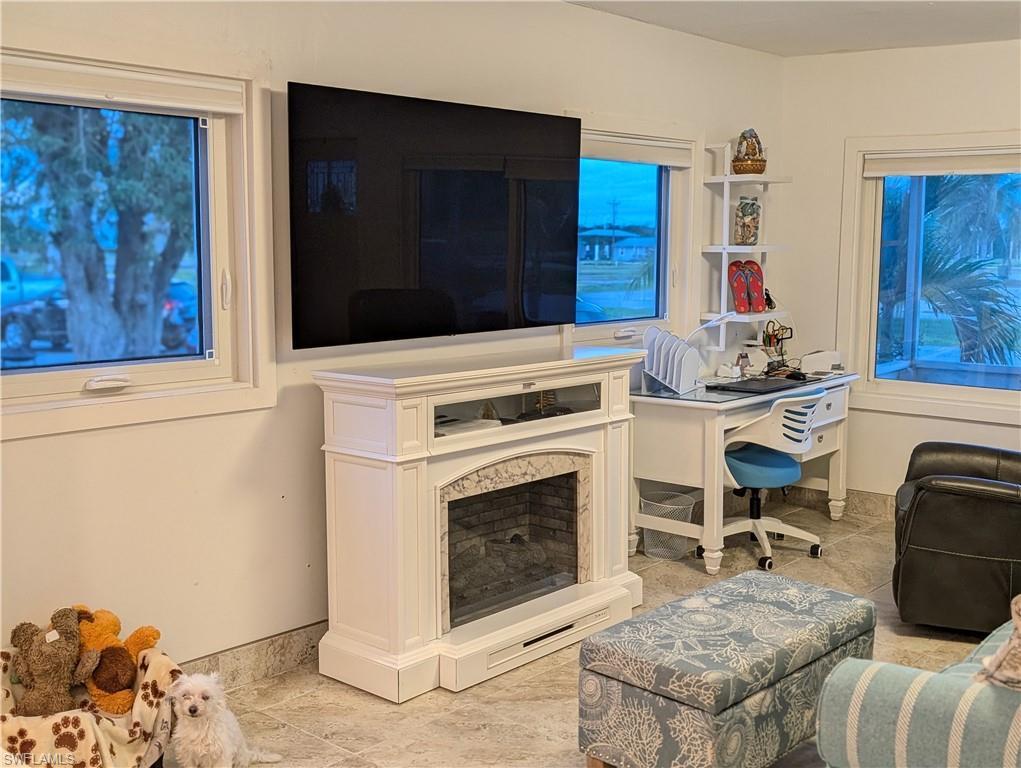 Image 2: Living room featuring light tile patterned floors and an office area