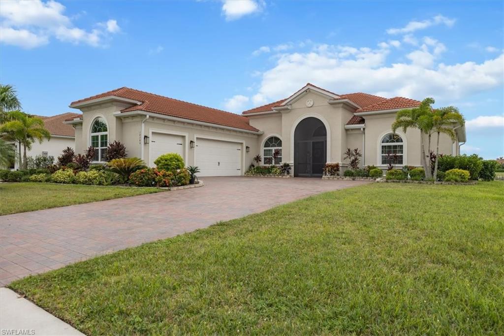 Image 2: Mediterranean / spanish home featuring stucco siding, an attached garage, a front yard, a tiled roof, and driveway